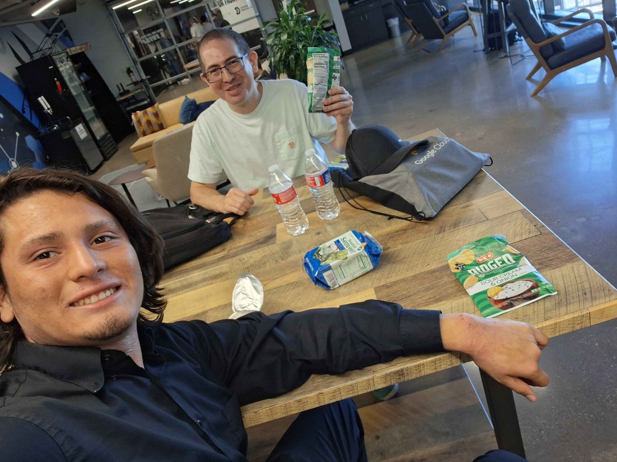 Adrian and his mentor Chris Lopez sharing snacks at a coworking space